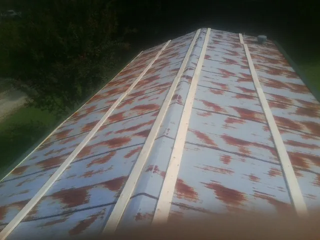 Rusted metal roof panels with new wood purlins before replacement — Storm Damage Roof Repair in Cataumet by Roofing Brothers
