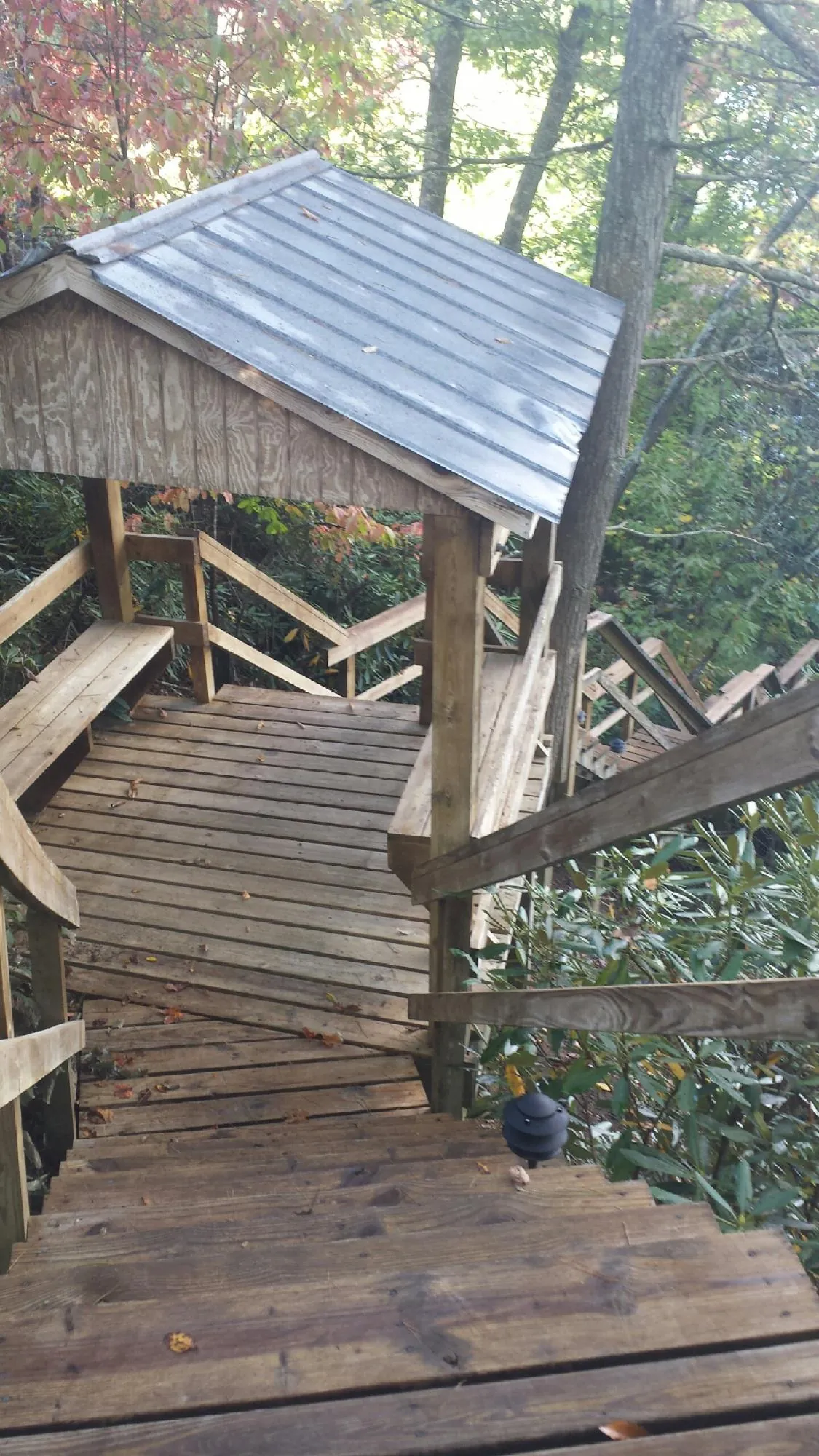 Metal roofed shelter over wooden steps on a wooded walkway — Skylight Repair & Installation work by our crew in Cataumet