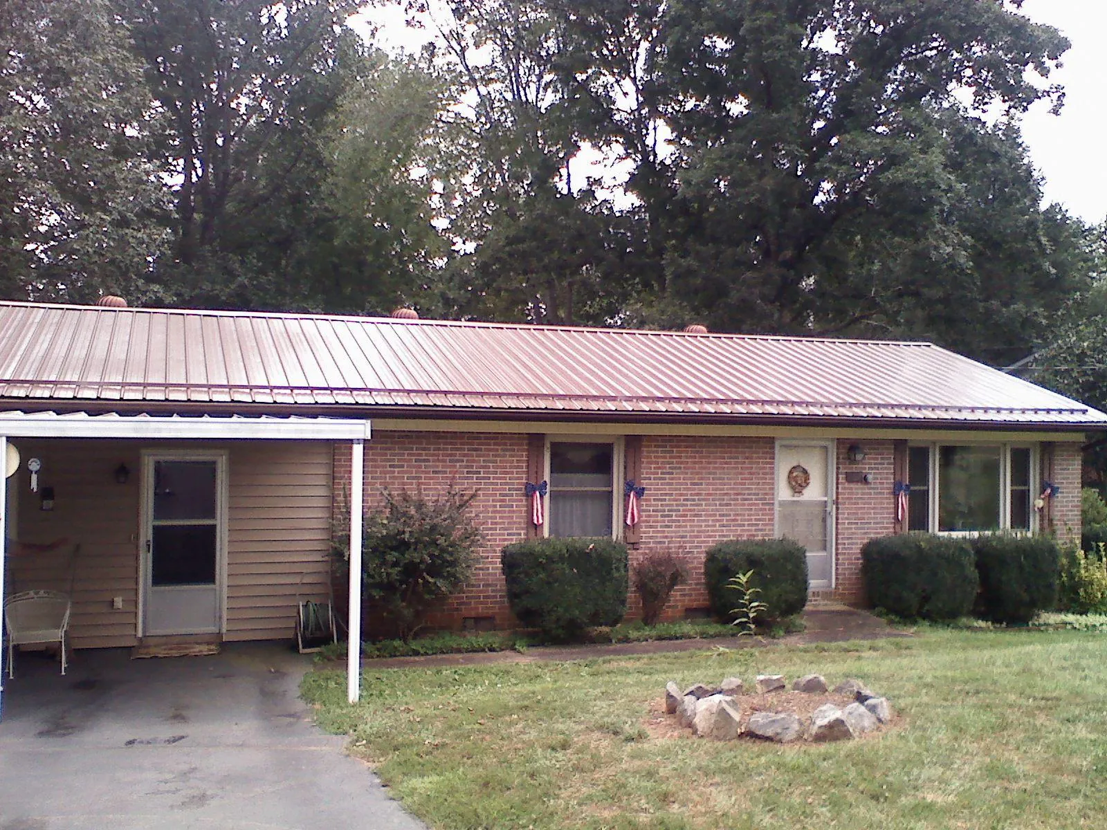 Bronze metal roof and carport on a brick ranch home — Roof Repair work by our crew in Cataumet